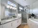 Elegant bathroom with granite counters, glass shower, soaking tub, and modern fixtures at 960 Mooring Ave # 202, Altamonte Springs, FL 32714