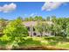 Exterior view of a condo building with lush green landscaping and a lake in the foreground at 960 Mooring Ave # 202, Altamonte Springs, FL 32714