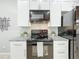 Updated kitchen featuring granite countertops, tile backsplash, and modern black appliances with white cabinetry at 960 Mooring Ave # 202, Altamonte Springs, FL 32714