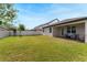 Beautiful backyard with a well-manicured lawn, covered patio, and white picket fence at 10072 Hampshire Oaks Dr, Orlando, FL 32825