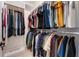 Organized walk-in closet with rods of hanging clothes, maximizing storage space at 10072 Hampshire Oaks Dr, Orlando, FL 32825