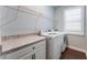 Well-equipped laundry room with modern washer and dryer, ample counter space, and overhead shelving at 10072 Hampshire Oaks Dr, Orlando, FL 32825