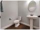 Neutral powder room featuring a pedestal sink, toilet, and bronze fixtures over tile flooring at 10072 Hampshire Oaks Dr, Orlando, FL 32825