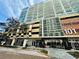 Condo building showcasing street-level commercial spaces, parking garage entrance, and modern architectural design in an urban setting at 101 S Eola Dr # 720, Orlando, FL 32801
