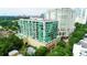 An aerial view of a modern condo building with balconies and pool, surrounded by lush landscaping in an urban area at 101 S Eola Dr # 720, Orlando, FL 32801