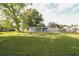Large grassy backyard with mature trees and a detached home with white siding at 1016 E Fillmore Ave, Orlando, FL 32809