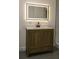 Modern bathroom featuring a wood vanity, LED mirror, and tiled walk-in shower at 1016 E Fillmore Ave, Orlando, FL 32809