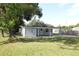 Detached single-Gathering home with white siding, a large backyard, and mature trees at 1016 E Fillmore Ave, Orlando, FL 32809