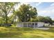 Detached single-Gathering home featuring a large backyard with mature trees and white siding at 1016 E Fillmore Ave, Orlando, FL 32809