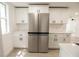 Bright kitchen featuring new stainless steel refrigerator and white cabinetry at 1016 E Fillmore Ave, Orlando, FL 32809