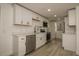 Modern kitchen with white cabinets, stainless steel appliances, quartz countertops, and plank flooring at 1016 E Fillmore Ave, Orlando, FL 32809
