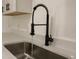 Close up of the kitchen sink and quartz countertop featuring an upgraded faucet at 1016 E Fillmore Ave, Orlando, FL 32809