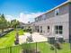 Spacious backyard featuring a stone patio with stylish seating, lighting, and a black metal fence at 1078 Vinsetta Cir, Winter Garden, FL 34787