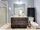Bathroom with dark vanity, white sink and toilet with view to shower at 1078 Vinsetta Cir, Winter Garden, FL 34787