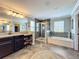 Bathroom showcasing dual sinks, a shower, and a soaking tub with stylish fixtures at 1078 Vinsetta Cir, Winter Garden, FL 34787