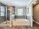 Bathroom with a glass enclosed shower and a soaking tub featuring a tiled backsplash at 1078 Vinsetta Cir, Winter Garden, FL 34787