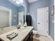 Bathroom with dark vanity, white countertop and toilet, framed by a large mirror at 1078 Vinsetta Cir, Winter Garden, FL 34787