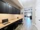 Home office featuring a long countertop desk, black cabinets and view into the living room at 1078 Vinsetta Cir, Winter Garden, FL 34787