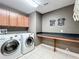 Functional laundry room with modern washer, dryer, countertop, and ample cabinet space at 1078 Vinsetta Cir, Winter Garden, FL 34787