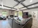 Cozy living room with a stone fireplace, coffered ceiling, and sliding glass doors leading to the outdoor patio at 1078 Vinsetta Cir, Winter Garden, FL 34787