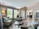 Comfortable living room showcasing tall windows, two club chairs, and view into the office with French doors at 1078 Vinsetta Cir, Winter Garden, FL 34787