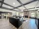 Open living space with a stone fireplace, leather seating, and an island kitchen with dark cabinetry at 1078 Vinsetta Cir, Winter Garden, FL 34787