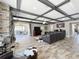 Spacious living room featuring a stone fireplace, coffered ceiling, tile flooring, and a leather sectional sofa at 1078 Vinsetta Cir, Winter Garden, FL 34787