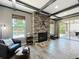 Inviting living room showcasing a stone fireplace, large windows, and access to the outdoor patio at 1078 Vinsetta Cir, Winter Garden, FL 34787
