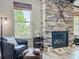 Charming living room displaying a stone fireplace, cozy seating area, and views of the surrounding landscape at 1078 Vinsetta Cir, Winter Garden, FL 34787