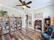 Well-lit office space with French doors, hardwood floors, multiple bookcases, and a ceiling fan at 1078 Vinsetta Cir, Winter Garden, FL 34787
