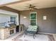 Inviting covered patio with built-in outdoor kitchen area, ceiling fan, and comfortable seating at 1078 Vinsetta Cir, Winter Garden, FL 34787