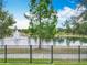 Scenic pond view with a fountain, lush trees, and a black metal fence at 1078 Vinsetta Cir, Winter Garden, FL 34787