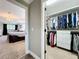 Walk-in closet adjacent to bedroom with a decorative chandelier and large bed at 1078 Vinsetta Cir, Winter Garden, FL 34787