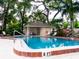 Beautiful community pool surrounded by mature trees, with a nearby clubhouse and comfortable lounge chairs at 110 S Primrose Dr, Orlando, FL 32803