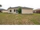 View of the backyard showing the home's exterior and sparse lawn at 1139 Humphrey Blvd, Deltona, FL 32738