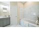 Bathroom features a tub, shower, marble tiling, and gray vanity at 1139 Humphrey Blvd, Deltona, FL 32738