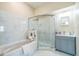 Bathroom features a tub, shower, marble tiling, and updated vanity at 1139 Humphrey Blvd, Deltona, FL 32738