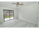 Bright bedroom with sliding glass door, wood-look floors, and a modern ceiling fan at 119 Ridgecrest Dr, Eustis, FL 32726