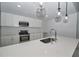 Well-lit kitchen with stainless steel appliances, quartz countertops, and stylish pendant lighting at 119 Ridgecrest Dr, Eustis, FL 32726