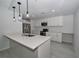 Modern kitchen with stainless steel appliances, white cabinets, quartz countertops, and large island at 119 Ridgecrest Dr, Eustis, FL 32726