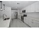 Contemporary kitchen with stainless steel appliances, white cabinetry, and quartz countertops at 119 Ridgecrest Dr, Eustis, FL 32726