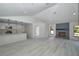 Open-concept living area with view of the kitchen, fireplace, and neutral walls at 119 Ridgecrest Dr, Eustis, FL 32726