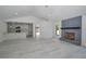 Open-concept living area features a brick fireplace, grey laminate flooring, and a kitchen view at 119 Ridgecrest Dr, Eustis, FL 32726