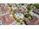 Aerial shot of a community pool with tropical landscaping, surrounding seating, and a relaxing jacuzzi at 12107 Poppy Field Ln # 105, Orlando, FL 32837