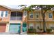 Inviting exterior of a two-story townhome with a private screened balcony, garage, and green front door at 12107 Poppy Field Ln # 105, Orlando, FL 32837