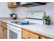 Close up of a kitchen cook top with white countertops and wood cabinets at 12107 Poppy Field Ln # 105, Orlando, FL 32837
