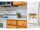 Close up view of a kitchen with white oven, wooden drawers and cabinets with decor at 12107 Poppy Field Ln # 105, Orlando, FL 32837