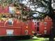 Exterior view of red brick building with tree and manicured landscaping at 1325 Rotonda Pt # 117, Lake Mary, FL 32746
