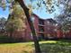 Exterior view of red brick apartment buildings with balconies and lush green landscaping, offering a serene residential environment at 1325 Rotonda Pt # 117, Lake Mary, FL 32746