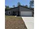 Charming single-story home featuring a modern exterior, two-car garage, and a well-manicured front yard at 14957 Sw 63Rd Court Rd, Ocala, FL 34473